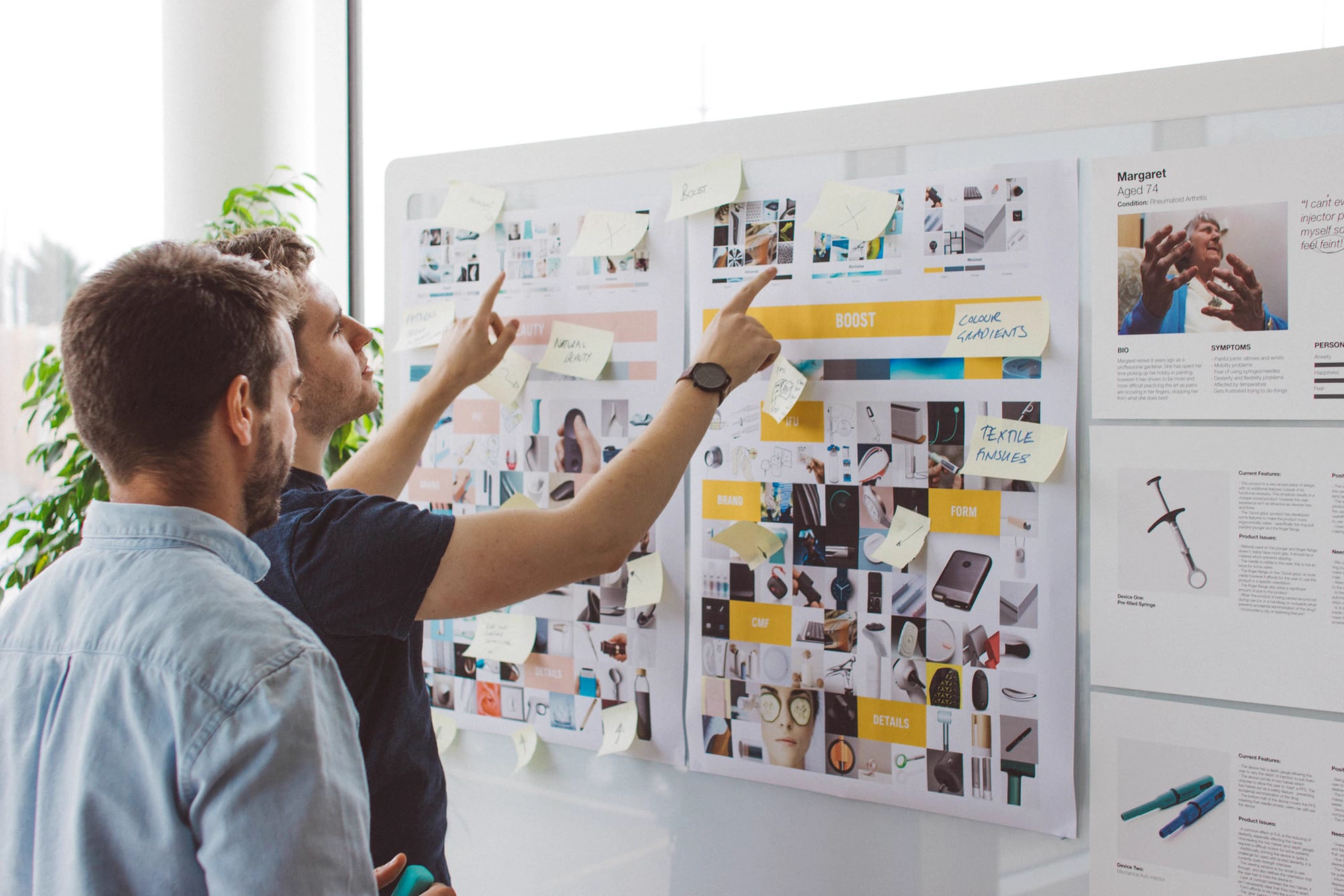 Designers reviewing brand and product boards on a wall
