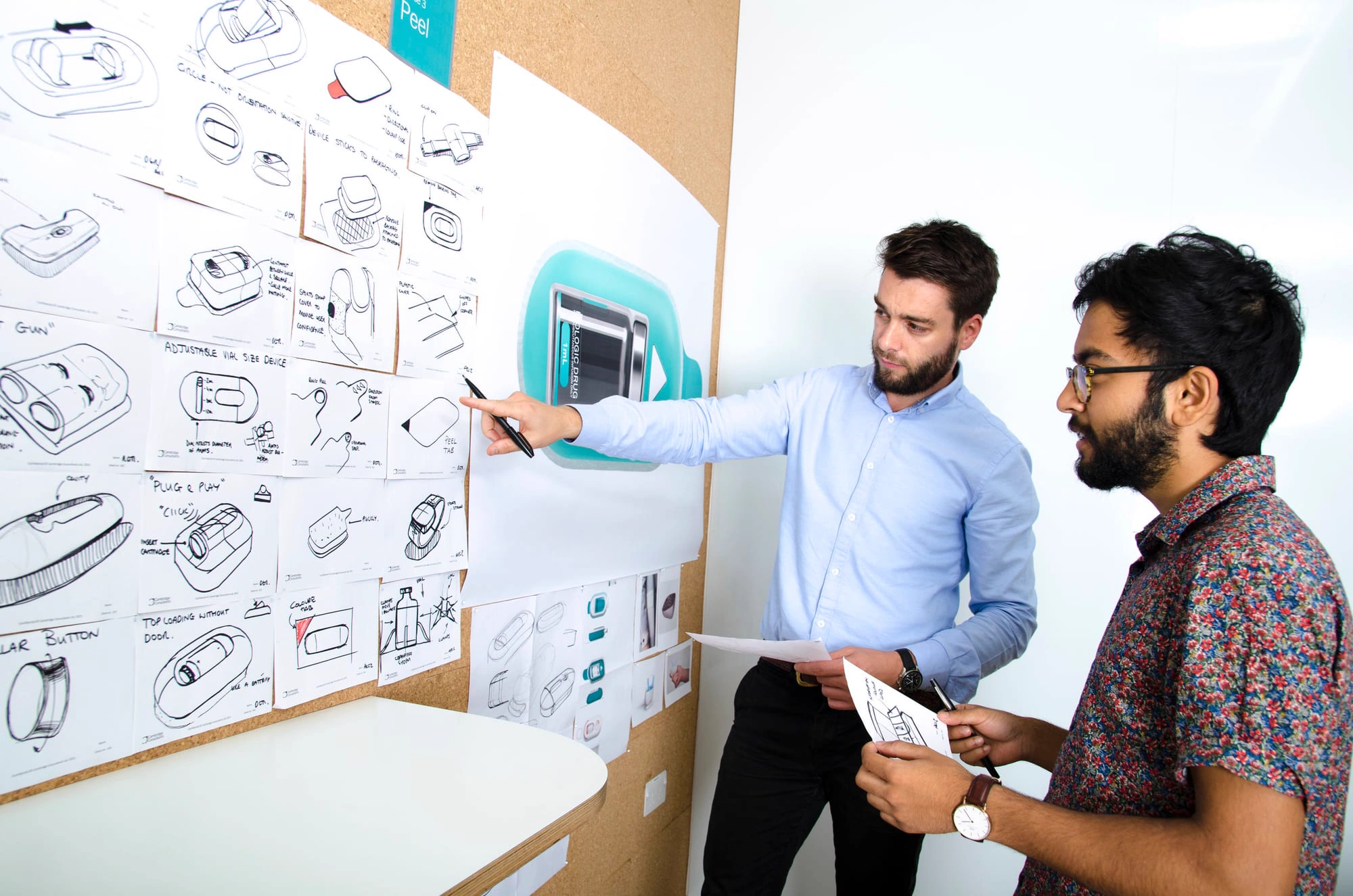 Designers reviewing concept sketches on a wall